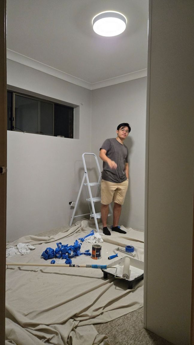 Toan standing in a newly painted room