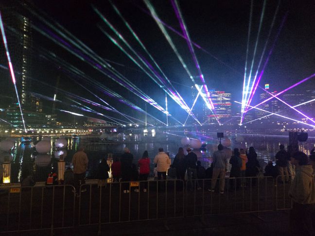 Colourful laser lights across the night sky of Sydney Darling Harbour.