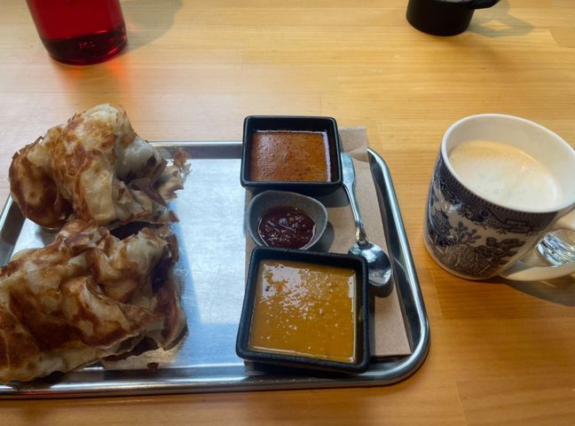 Two pieces of roti with three curry sauces